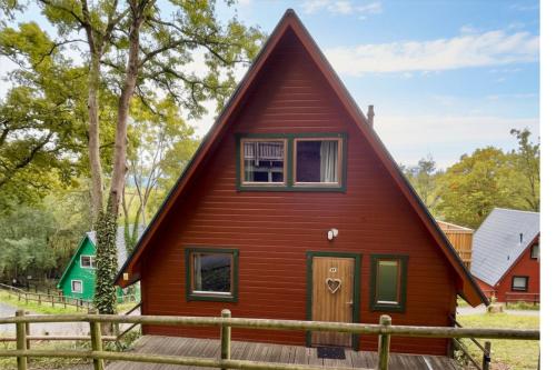 a red house with a gambrel roof at Primrose Lodge with Hot Tub near Waterpark and Trails in Chudleigh