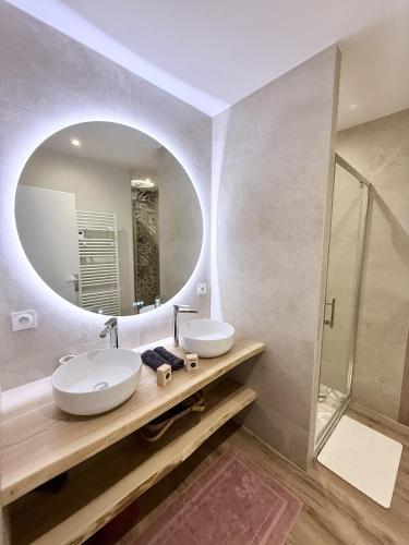 a bathroom with two sinks and a mirror at L'escale de l'oisans in Livet-et-Gavet