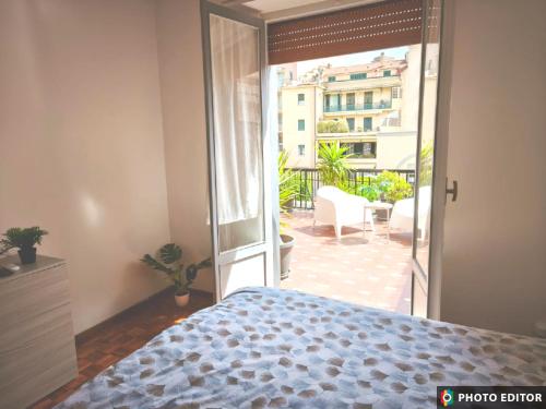 a bedroom with a bed and an open door to a patio at Foce 24 - City Garden 2 - in Imperia