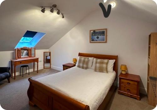 a bedroom with a bed and a desk and a window at Chapel House Accommodation in Culgaith