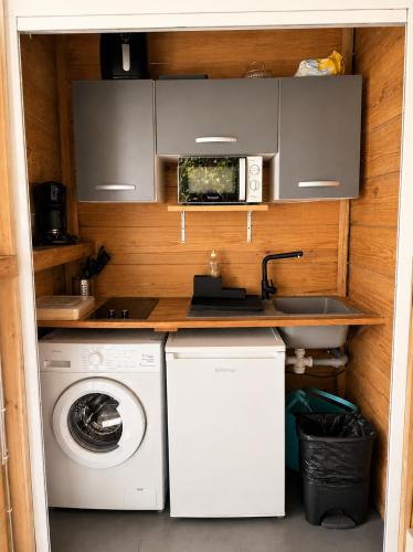 a kitchen with a washing machine and a microwave at evasion guadeloupe in Malgré Tout