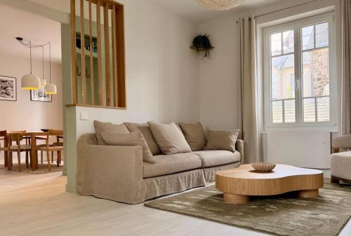 a living room with a couch and a coffee table at GIte de la Grande Plage in Pléneuf-Val-André