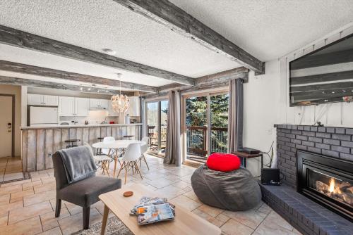 a living room with a fireplace and a table at 29C by SkyRun Aspen in Snowmass Village