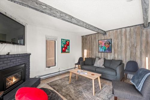 a living room with a couch and a fireplace at 29C by SkyRun Aspen in Snowmass Village