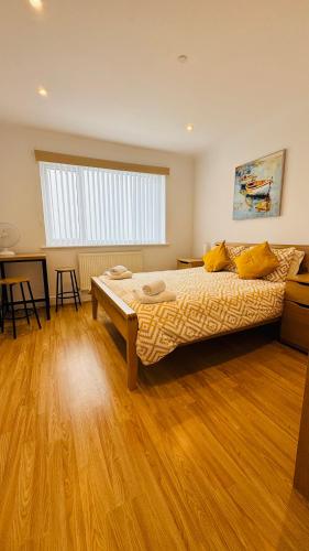 a bedroom with a bed and a wooden floor at Palm Bay Residency in Cliftonville
