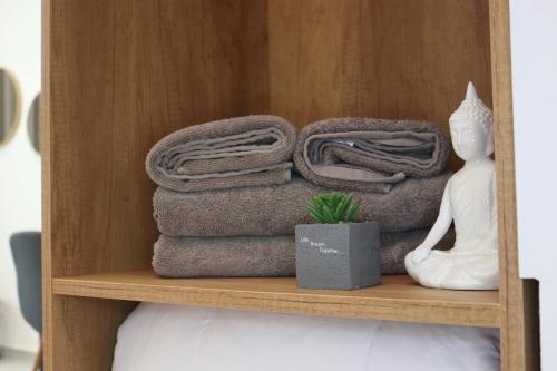 a shelf with towels and a statue of a woman at Megan's Villa in Durrës