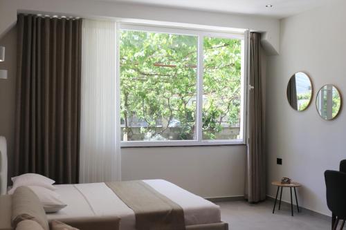 a bedroom with a bed and a large window at Megan's Villa in Durrës