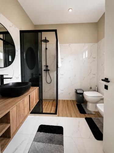 a bathroom with a black sink and a toilet at L olive Villa in Zogaji
