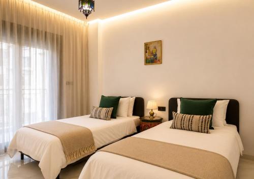 two beds sitting next to each other in a room at Azra Mila Appart luxe famille uniquement in Saïdia