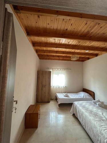 a bedroom with two beds and a wooden ceiling at Liberty Home Μάκρη in Alexandroupoli