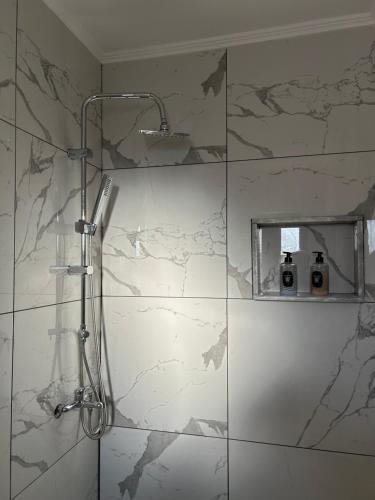 a shower in a bathroom with a marble wall at Liberty Home Μάκρη in Alexandroupoli