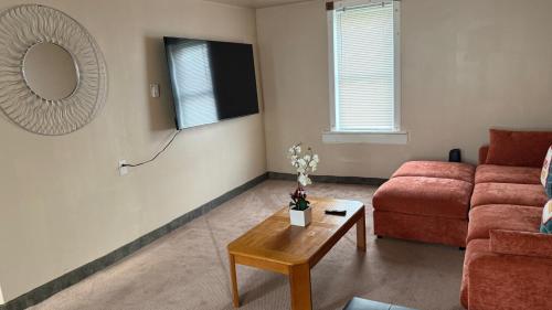 a living room with a red couch and a table at Plattsburgh Stay in Plattsburgh