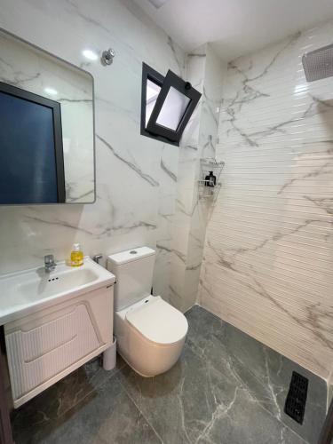 a bathroom with a toilet and a sink and a mirror at Azra Mila Appart luxe famille uniquement in Saïdia