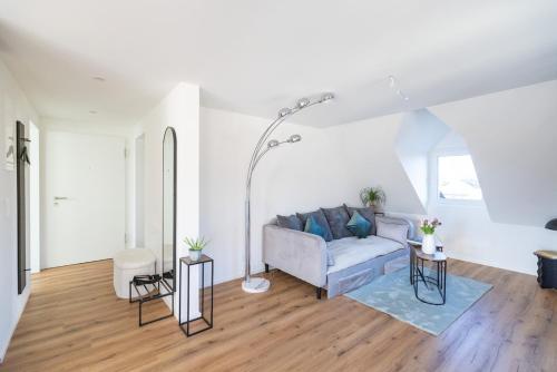 a living room with a couch and two tables at Sali Suite - Modern Attic Stay in Arbon