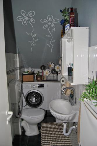 ein Badezimmer mit Toilette, Waschbecken und Waschmaschine in der Unterkunft Amalia's Maisonette in Marathos