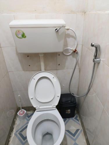 a small bathroom with a toilet with a shower at Meg Cozy Homes Executive 1Bedroom and 2Bedroom Apartments Near Rupa Mall The Noble Hotel & Poa Place Resort in Eldoret