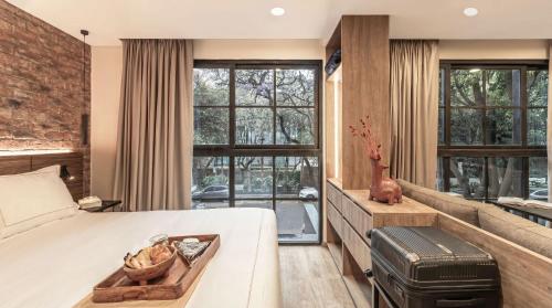 a bedroom with a bed and a brick wall at Kukun Edition El Angel in Mexico City