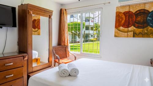 a bedroom with a bed and a tv and a window at La Marina Condominiums by Monyxbnb in Puerto Vallarta