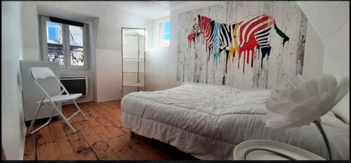 a bedroom with a bed and a painting of a zebra at Le Loft des Remparts in Murat