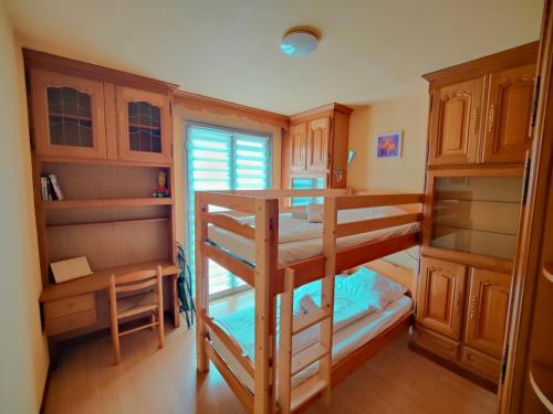 a room with two bunk beds and a desk at Le Repère du Bien-être - Maison 5 chambres, Sauna, Cinéma in Remiremont
