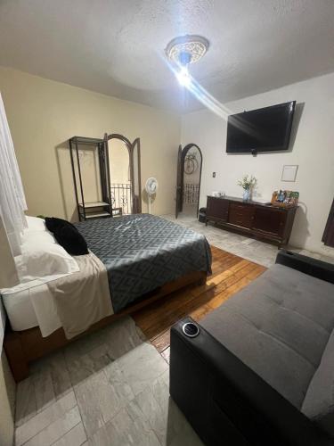 a bedroom with a bed and a flat screen tv at Habitación 4 Casa Minerva in Puebla