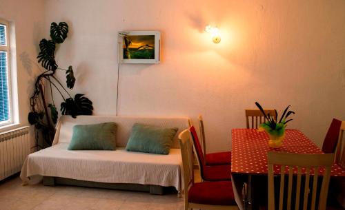 een kamer met een bed met een tafel en een stoel bij Apartment Gulić in Rab