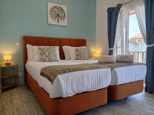 a large bed in a bedroom with a window at The Olive Hill Guesthouse in Batalha