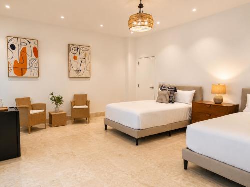 a bedroom with two beds and a table and chairs at Miara - Celebrity villa in Casa de Campo! in La Romana