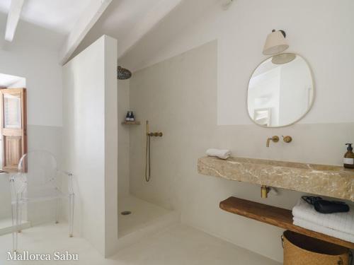 a bathroom with a shower and a sink and a mirror at C'an Llum in Deia