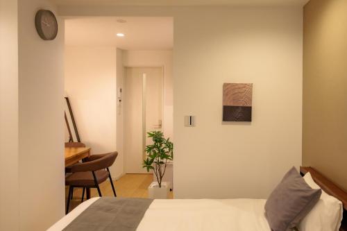 a bedroom with a bed and a table and a desk at Solis Studio Miyako SeaSide in Miyako-jima
