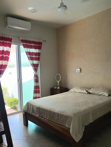 a bedroom with a bed and a large window at Casa Marbo in Malucano