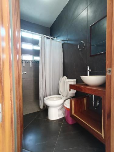a bathroom with a white toilet and a sink at Casa Marbo in Malucano