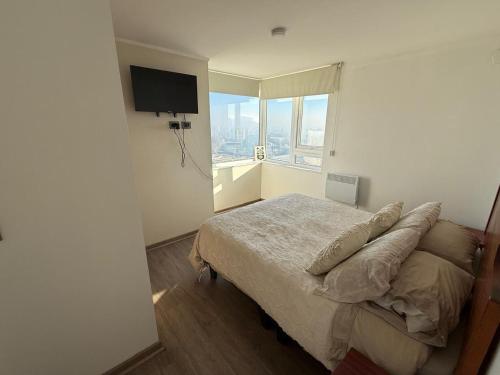 a bedroom with a bed and a large window at Departamento Blanco Encalada in Temuco