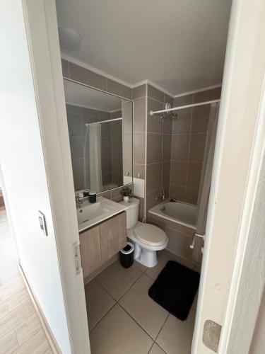 a bathroom with a toilet and a tub and a sink at Departamento Blanco Encalada in Temuco