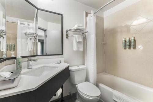 a bathroom with a sink and a toilet and a tub at Best Western Eagles Inn in Morehead