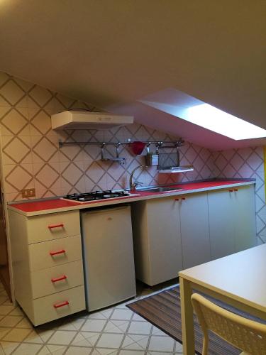 ジャルディーニ・ナクソスにあるAppartamento Dromの小さなキッチン(白いキャビネット、コンロ付)