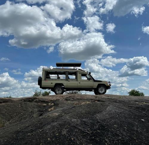 a vehicle parked on top of a dirt field at Mara oasis in Mara Simba