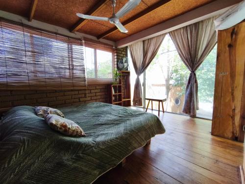 a bedroom with a large bed in a room with windows at Casa Santi Tepoztlán in Tepoztlán