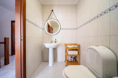 a bathroom with a sink and a toilet and a mirror at Quinta da Mina 13 in Azambuja