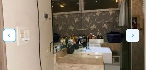 a bathroom with a sink with two arrows on the wall at Nosso lar hostel in Cuiabá