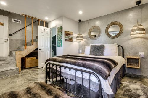a bedroom with a bed and a staircase and mirrors at 2 Mi to Lake Gregory! Chic Crestline Base Camp in Crestline