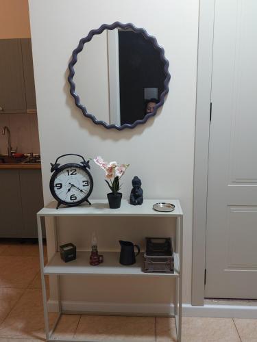a shelf with a clock and a mirror on a wall at The Velvet Stay in Tbilisi City
