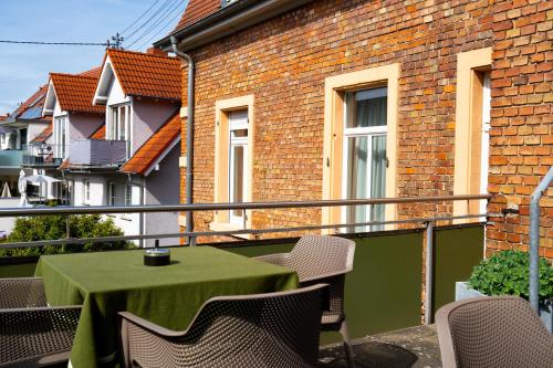 a green table and chairs on a balcony at Hotel Grünshof in Walldorf