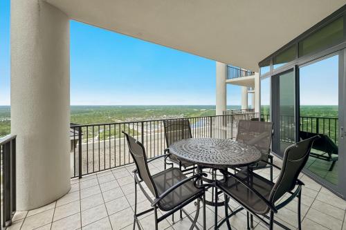 a patio with a table and chairs on a balcony at The Oasis at Orange Beach Unit 1816 in Orange Beach