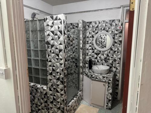 a bathroom with black and white tiles on the wall at Hillside Haven in Cochrane