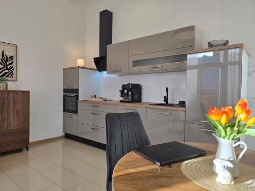 a kitchen with a table with a vase of flowers at Erdgeschoss Juwel direkt hinter dem Markt I Terrasse & Parkplatz I ruhig & privat in Viersen
