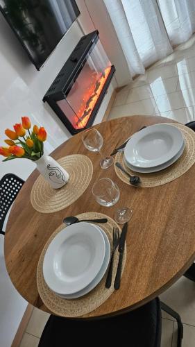 a wooden table with two white plates and flowers on it at Erdgeschoss Juwel direkt hinter dem Markt I Terrasse & Parkplatz I ruhig & privat in Viersen