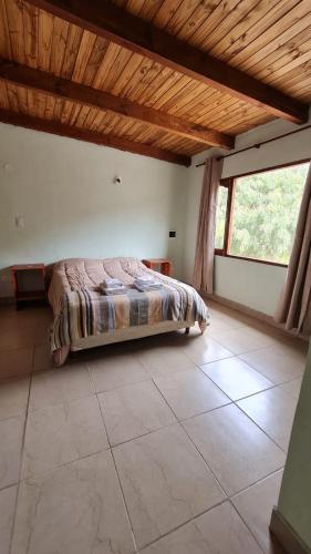 a bedroom with a bed and a large window at Dúplex céntrico LAS SOFIAS - PURMAMARCA in Purmamarca