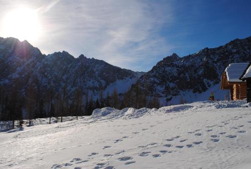 a snow covered mountain with the sun in the background at Ferienwohnung Mostecky in Ferlach