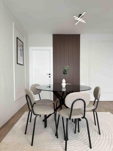 a dining room with a black table and chairs at Zafiro Apartment, City Center in Kavadarci